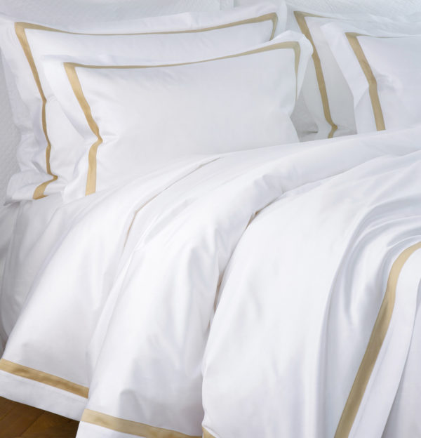 La parure de lit New York fabriqué à partir de satin 100% de coton, tissu extrêmement doux et soyeux . Dans cette collection la couleur blanche du tissu principal contraste avec la garniture dorée.